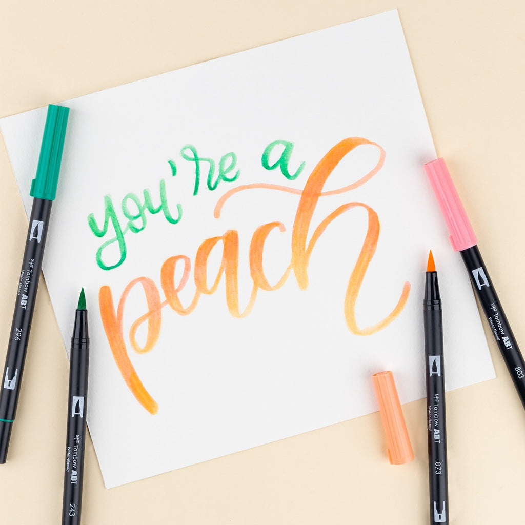 Colorful calligraphy on paper with markers on a beige background